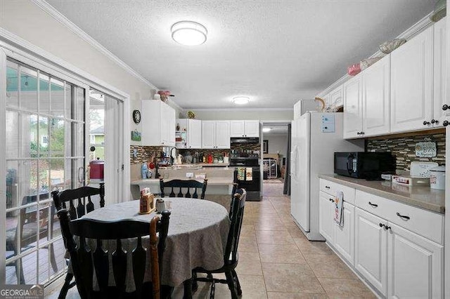 dining area with light tile patterned flooring, a textured ceiling, and ornamental molding