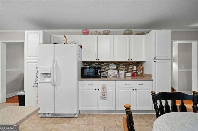 kitchen with white fridge with ice dispenser, backsplash, white cabinetry, and a textured ceiling