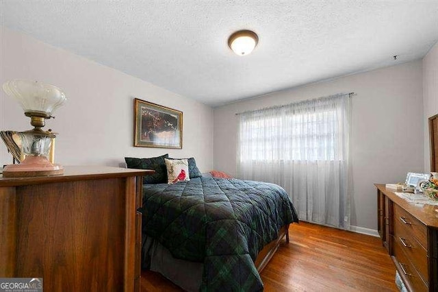 bedroom featuring hardwood / wood-style flooring and a textured ceiling