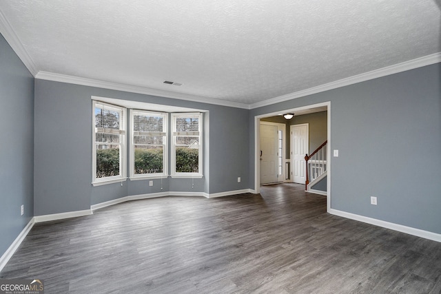 spare room with crown molding, dark wood-type flooring, and a textured ceiling