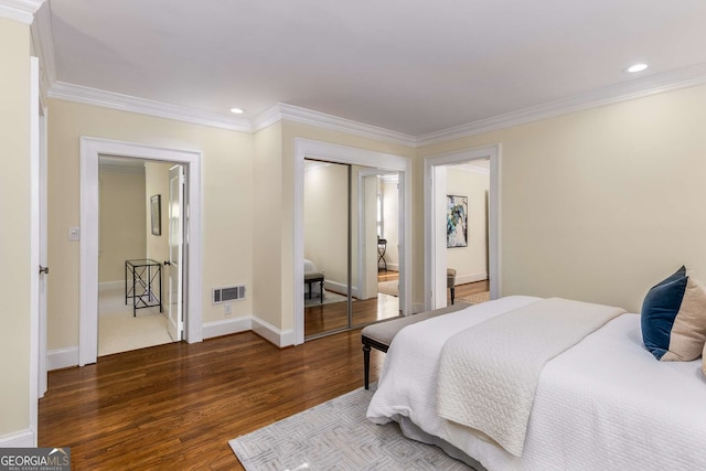 bedroom with a closet, crown molding, and dark hardwood / wood-style flooring