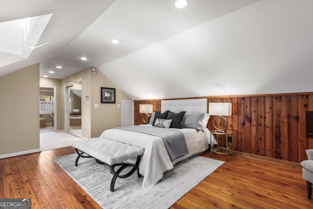 bedroom with wood-type flooring and vaulted ceiling with skylight