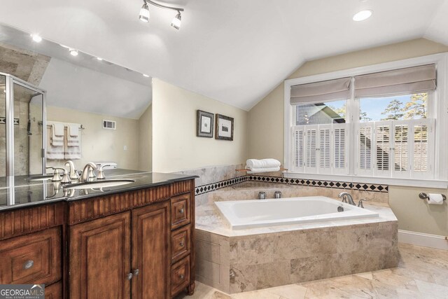 bathroom featuring shower with separate bathtub, vaulted ceiling, and vanity