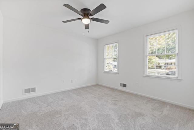 spare room with light colored carpet and ceiling fan