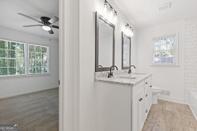 bathroom with toilet, ceiling fan, and vanity