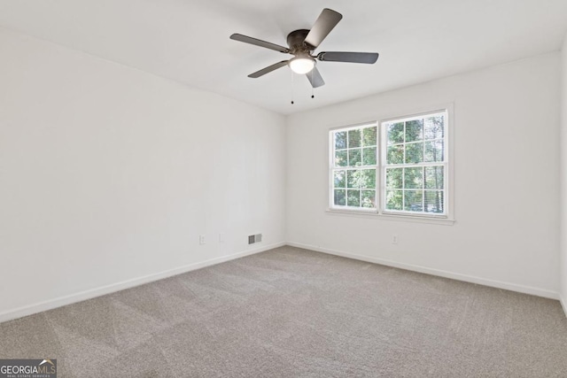 unfurnished room with ceiling fan and carpet