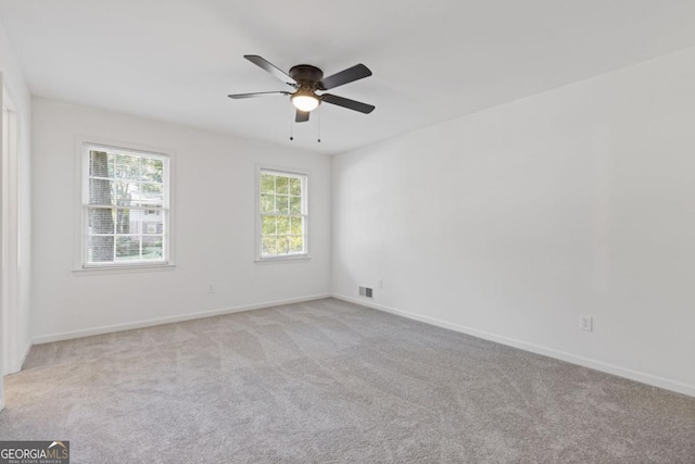 spare room featuring ceiling fan and light colored carpet