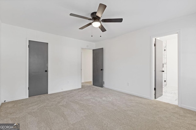 unfurnished bedroom with light colored carpet, connected bathroom, and ceiling fan