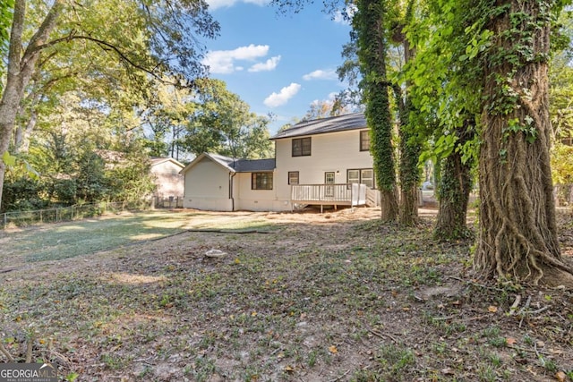 rear view of house with a yard and a deck