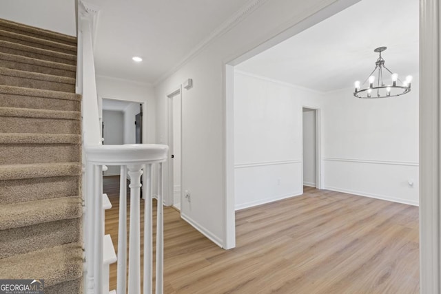 interior space featuring an inviting chandelier, ornamental molding, and hardwood / wood-style floors