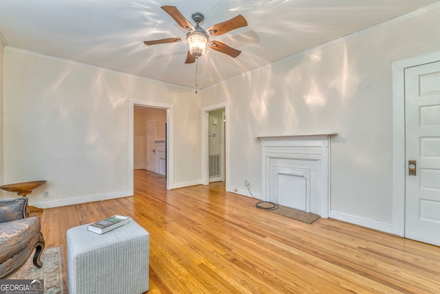 living room featuring light wood-type flooring, ceiling fan, and ornamental molding