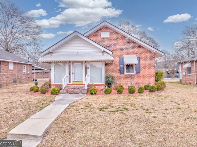 bungalow with central air condition unit and a front lawn