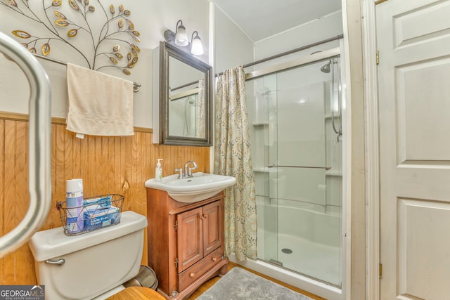 bathroom featuring toilet, wooden walls, an enclosed shower, and vanity