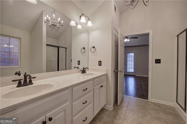 bathroom with a shower with door, vanity, lofted ceiling, and tile patterned floors