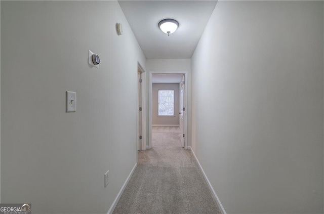 hall with light colored carpet