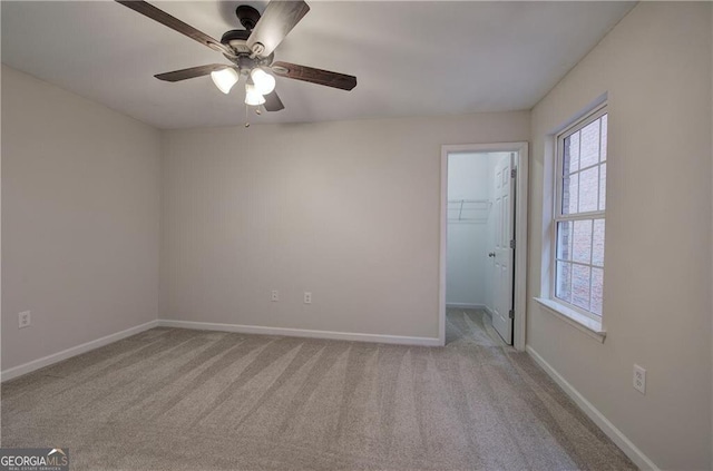 carpeted spare room featuring ceiling fan