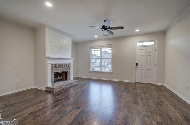 unfurnished living room featuring a brick fireplace, ornamental molding, dark hardwood / wood-style floors, and ceiling fan