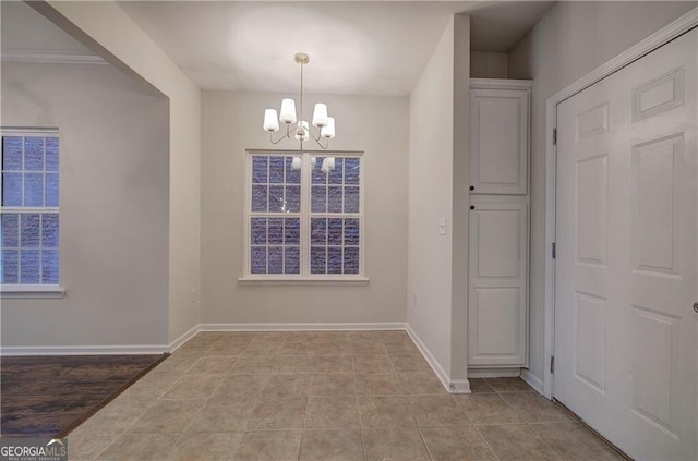 unfurnished dining area with a chandelier and light tile patterned floors