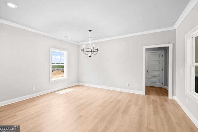 unfurnished dining area featuring ornamental molding, light wood-type flooring, and a chandelier