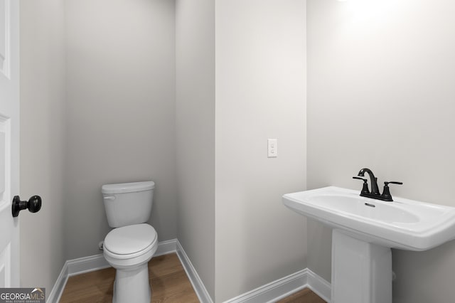 bathroom with sink, toilet, and hardwood / wood-style floors