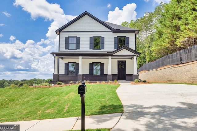 view of front of home featuring covered porch and a front yard