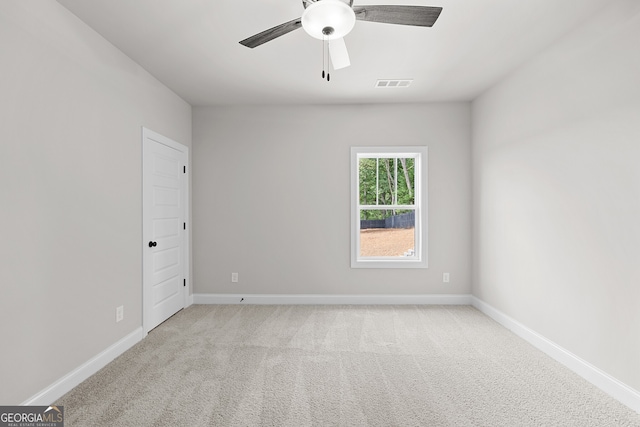 empty room with ceiling fan and light carpet