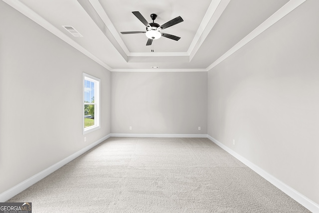 carpeted empty room with a tray ceiling, ornamental molding, and ceiling fan