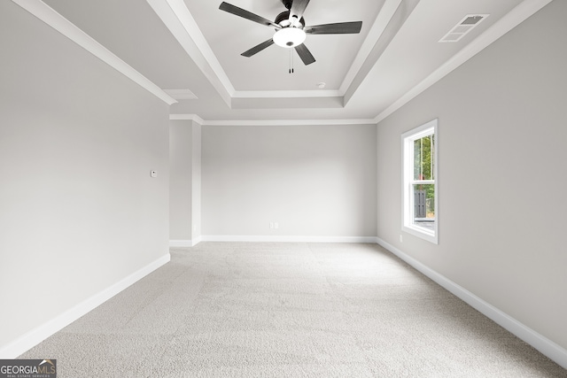 carpeted empty room featuring ceiling fan, a tray ceiling, and ornamental molding