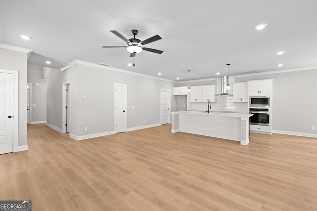 unfurnished living room with light hardwood / wood-style floors, sink, and crown molding