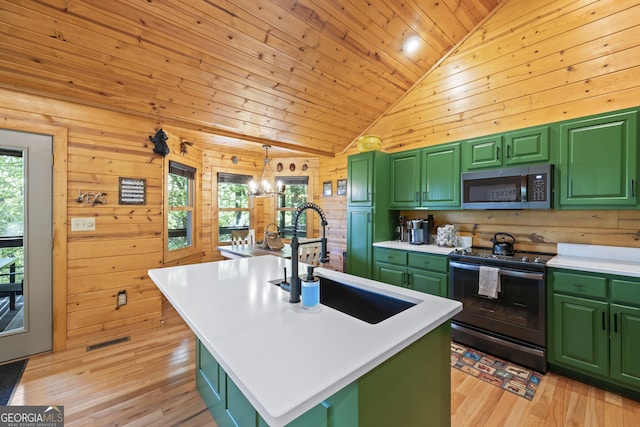 kitchen featuring a kitchen island with sink, green cabinets, and appliances with stainless steel finishes