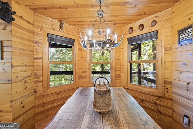 dining space with wooden walls, a notable chandelier, and wood ceiling