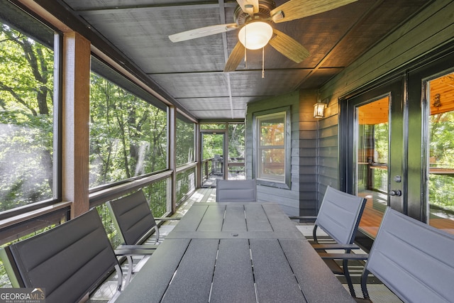 unfurnished sunroom with ceiling fan