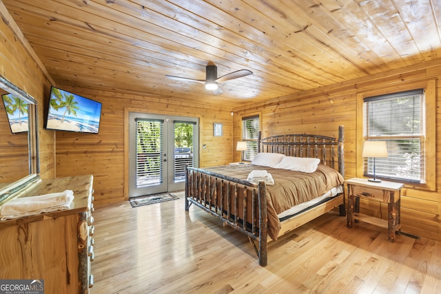 bedroom with light hardwood / wood-style floors, wood ceiling, wooden walls, access to outside, and ceiling fan