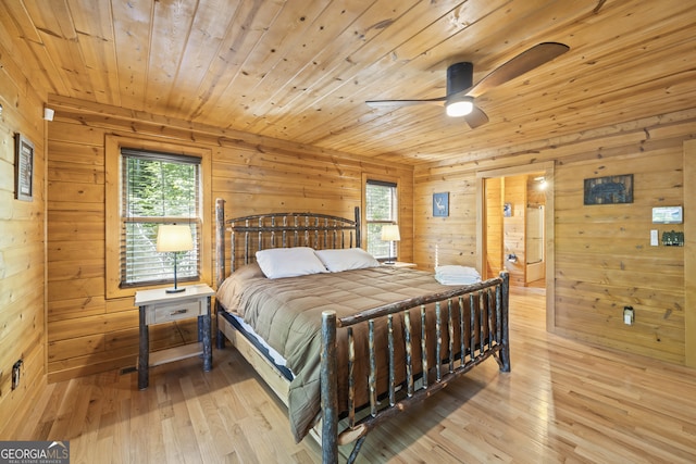 bedroom featuring ceiling fan, wooden ceiling, light hardwood / wood-style flooring, and wood walls