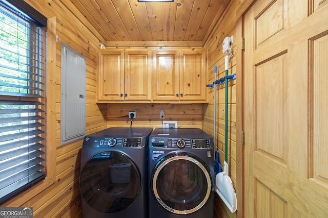 laundry room featuring electric panel, wooden ceiling, separate washer and dryer, cabinets, and wood walls