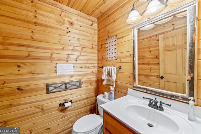 bathroom featuring toilet, vanity, wood walls, and wood ceiling