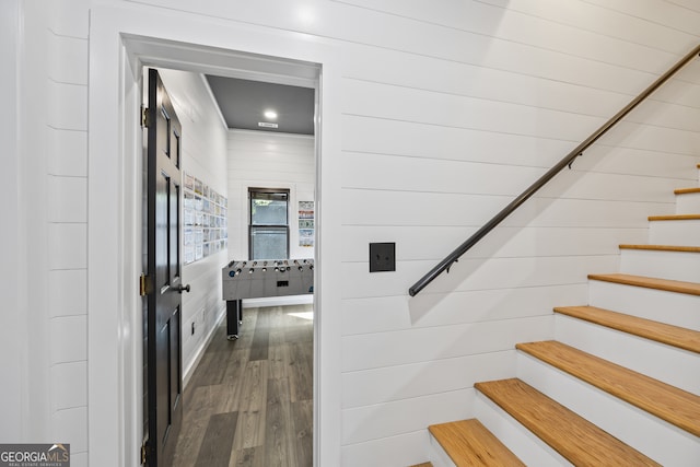 stairs featuring hardwood / wood-style floors and wood walls