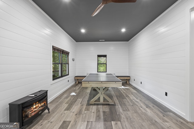 recreation room with wood-type flooring and wooden walls