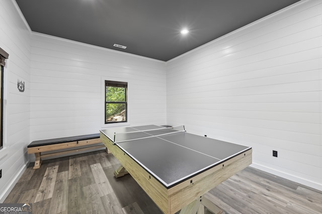 playroom with wood-type flooring and wooden walls