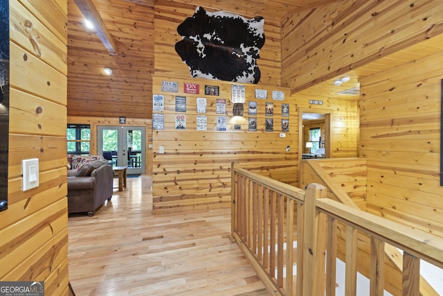 corridor featuring wooden ceiling, light hardwood / wood-style floors, wooden walls, and beamed ceiling