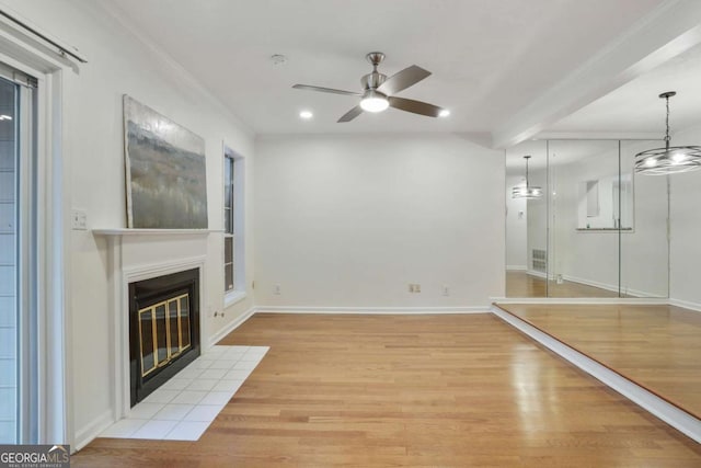 workout room with light wood-type flooring, ceiling fan, and ornamental molding