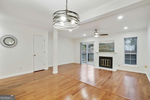 unfurnished living room with hardwood / wood-style flooring, ceiling fan, and crown molding