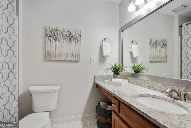 bathroom with vanity, toilet, and curtained shower