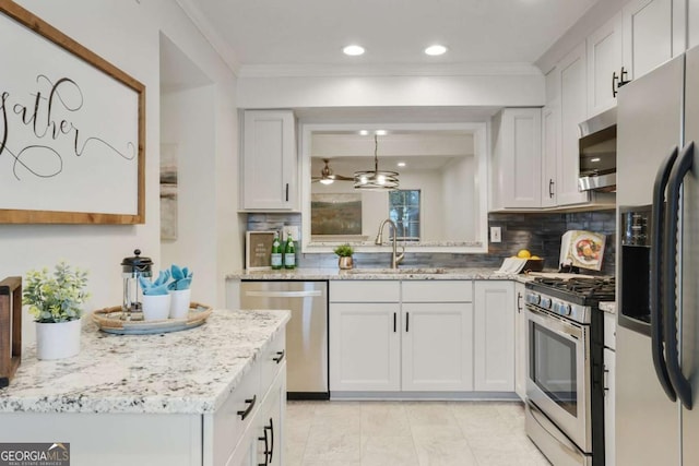 kitchen featuring light stone countertops, appliances with stainless steel finishes, white cabinets, sink, and backsplash