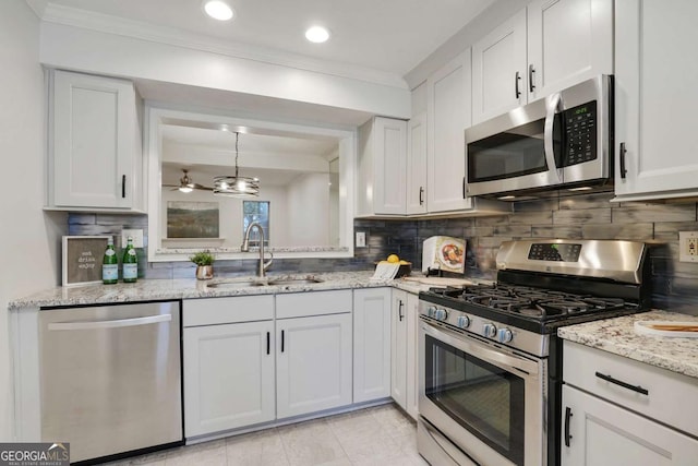 kitchen with decorative backsplash, sink, white cabinets, and appliances with stainless steel finishes