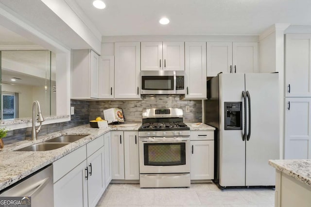 kitchen featuring decorative backsplash, sink, white cabinetry, and stainless steel appliances