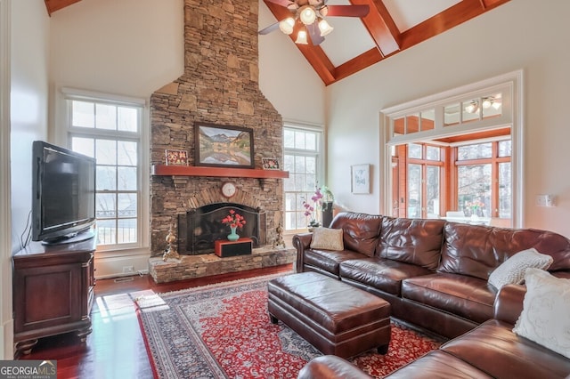 living room with ceiling fan, beam ceiling, a fireplace, hardwood / wood-style floors, and high vaulted ceiling