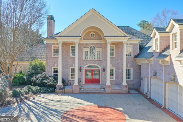 neoclassical home featuring a garage