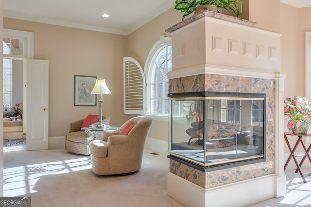 sitting room with light colored carpet, ornamental molding, and a fireplace