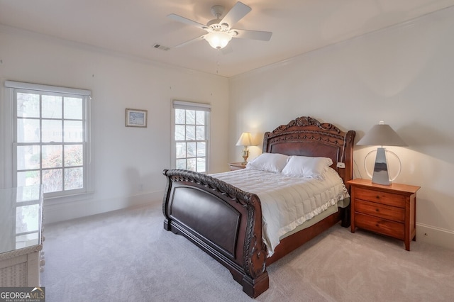 bedroom with ceiling fan, light colored carpet, and crown molding